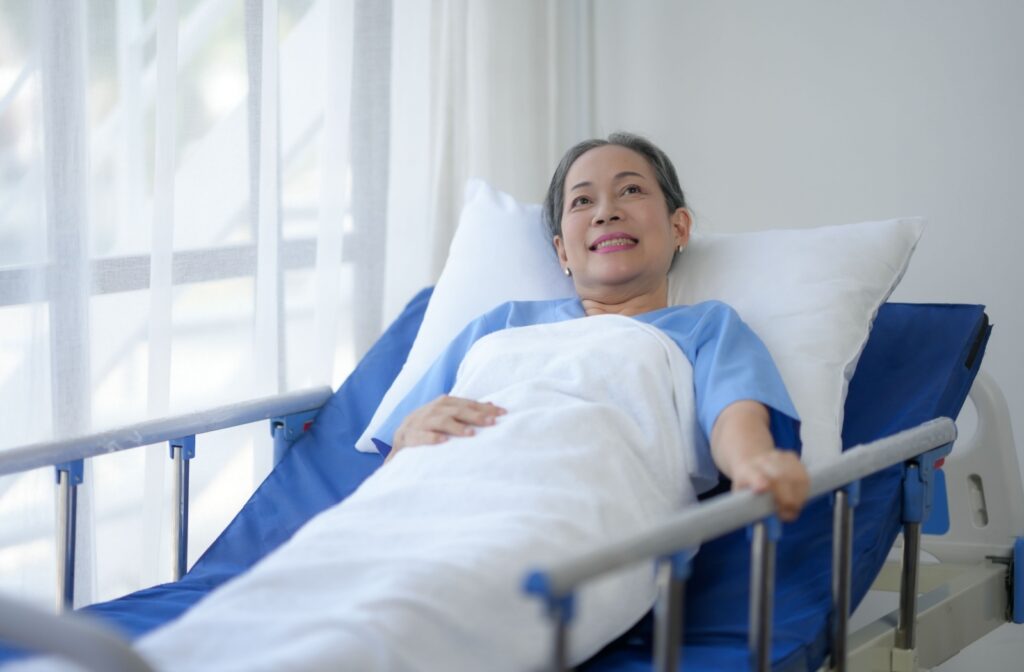 A smiling older adult in a bed in respite care.